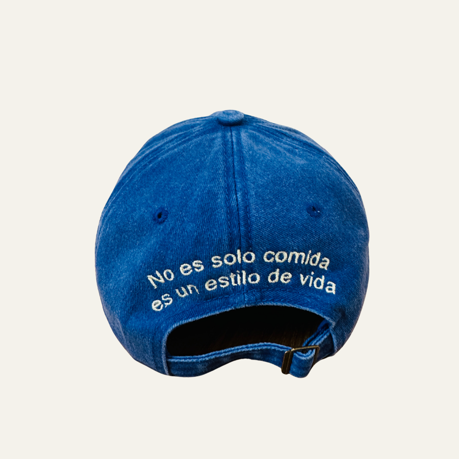 Parte trasera de la gorra azul con el lema No es solo comida, es un estilo de vida